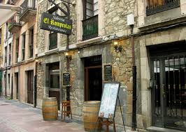 Vista exterior del local en la calle, con su fachada típica de sidrería y decoración rústica.