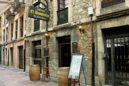 Vista exterior del local en la calle, con su fachada típica de sidrería y decoración rústica.